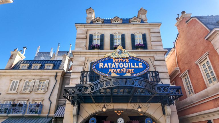 Use the Disney rider switch service to save time on select attractions and rides at Walt Disney World. Entrance to Remy's Ratatouille Adventure framed by Paris inspired buildings under a bright blue sky. The large blue sign reading "Remy's Ratatouille Adventure" hangs above the attraction entrance.